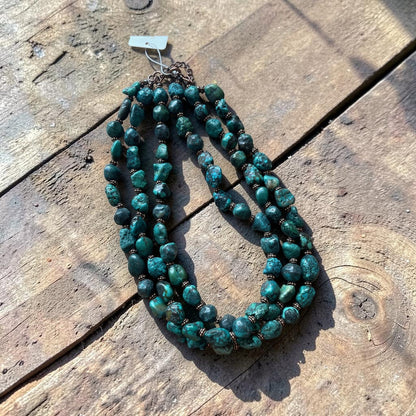Green beaded necklace on a wooden surface