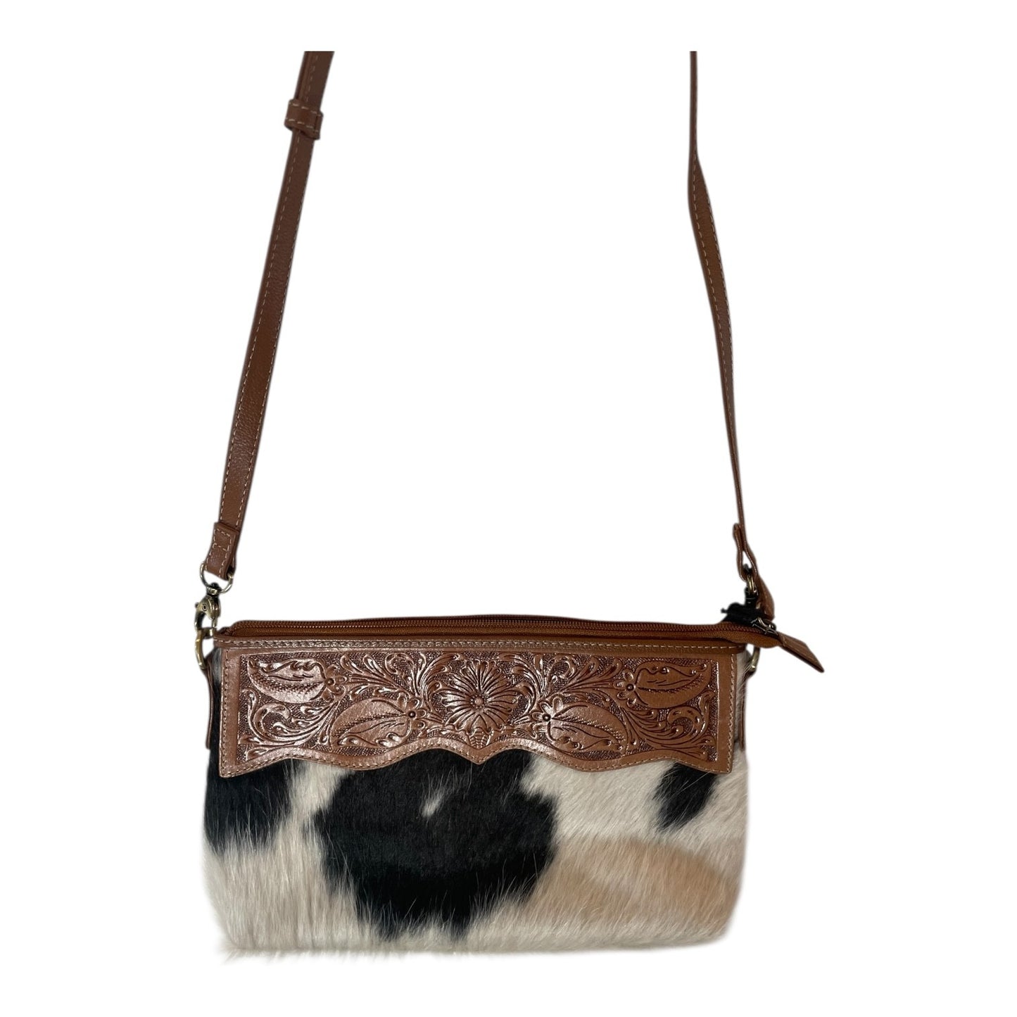 Cowhide handbag with brown leather strap and decorative panel on a white background
