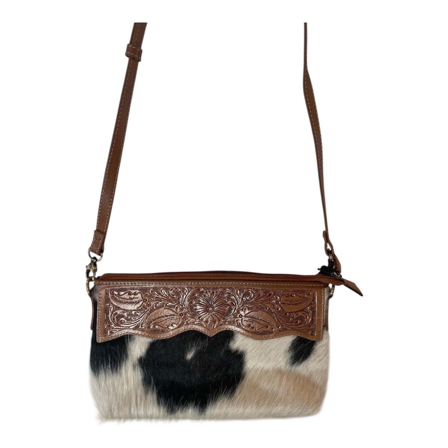 Cowhide handbag with brown leather strap and decorative panel on a white background