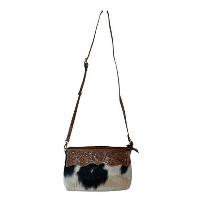 Handbag with cowhide pattern and brown leather accents on a white background