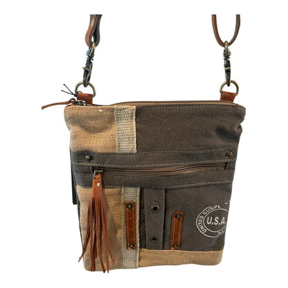 Canvas crossbody bag with leather accents on a white background