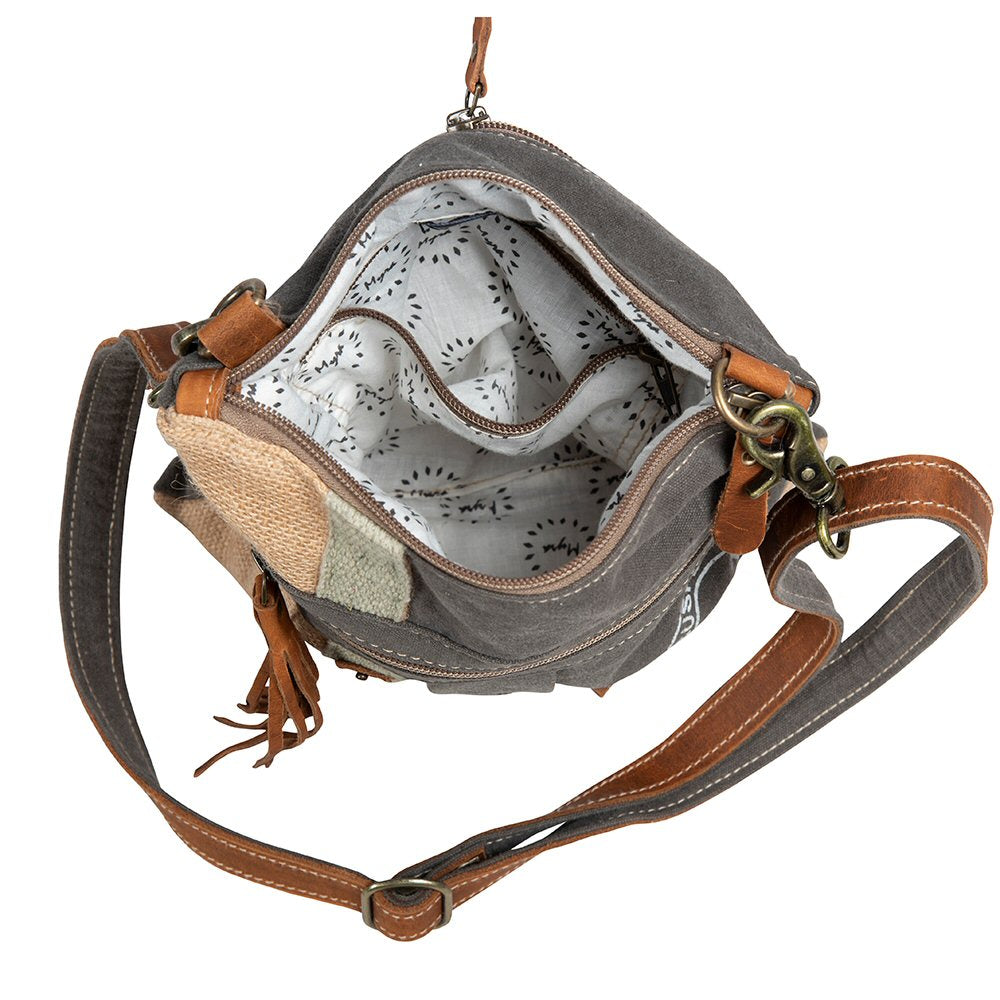 Open handbag with brown strap and gray interior on a white background