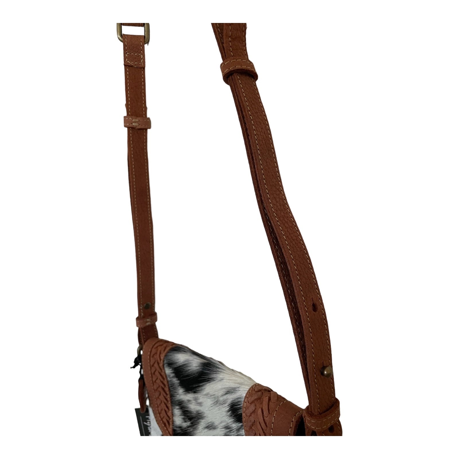 Brown leather strap with a black and white cowhide patch on a white background