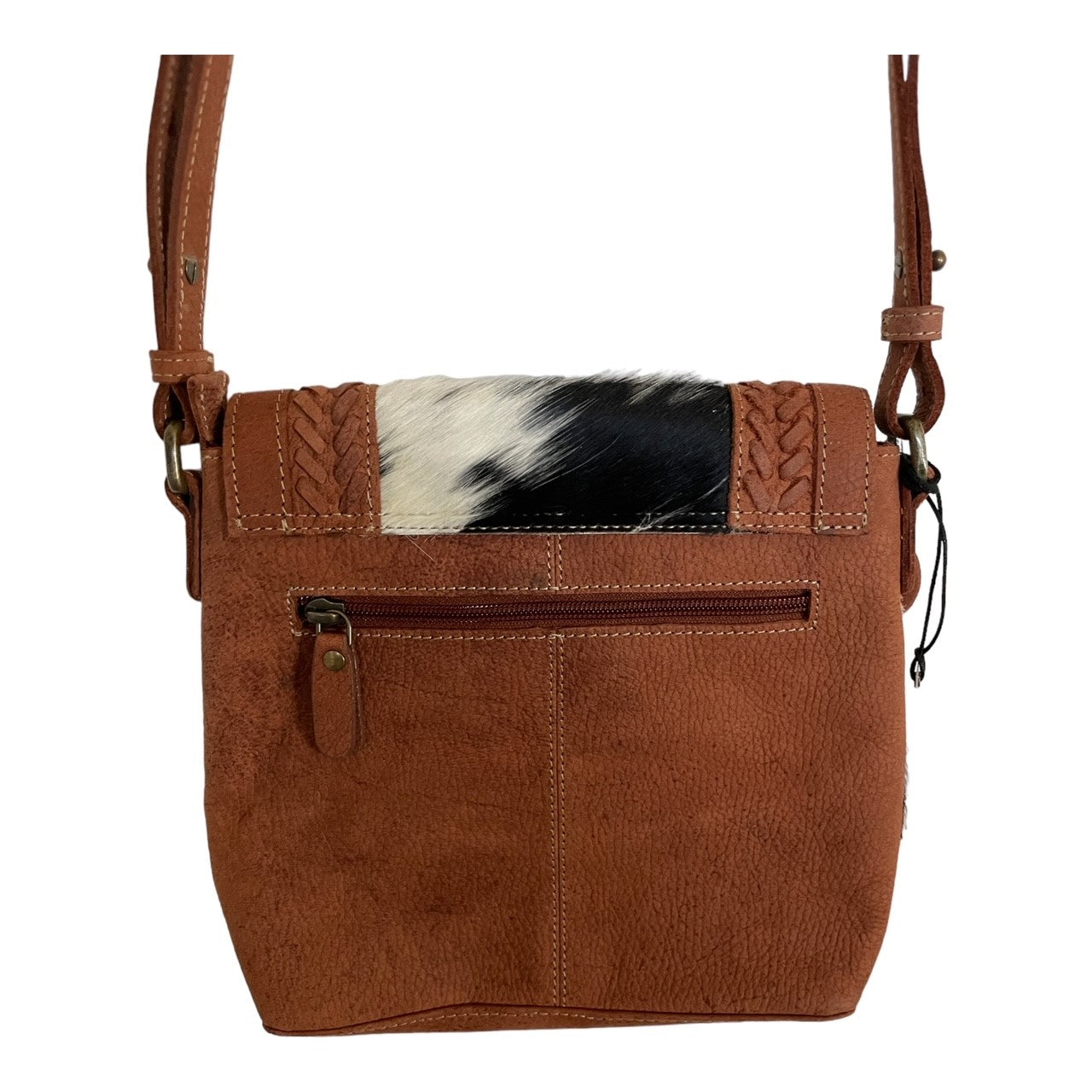 Brown leather crossbody bag with cowhide patch on a white background