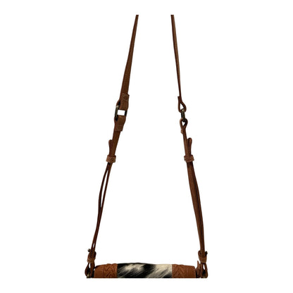 Brown leather bridle with a black and white patterned noseband on a white background